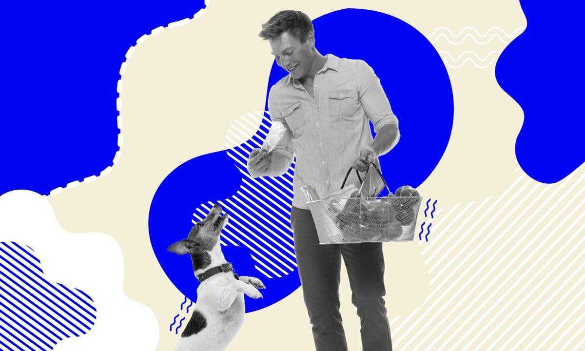 man feeding vegetables to a happy dog